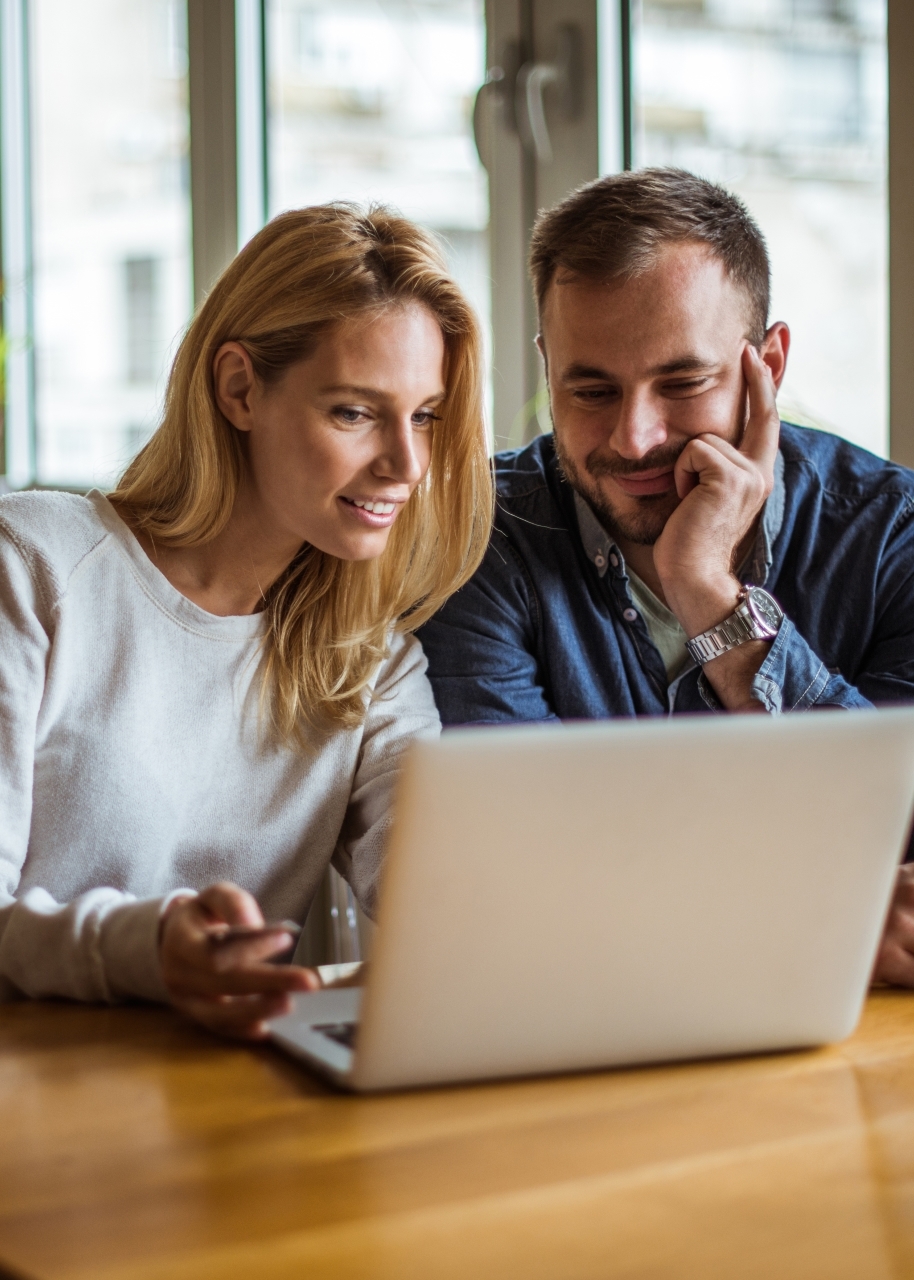 Couple looking at laptop at dinning room table
